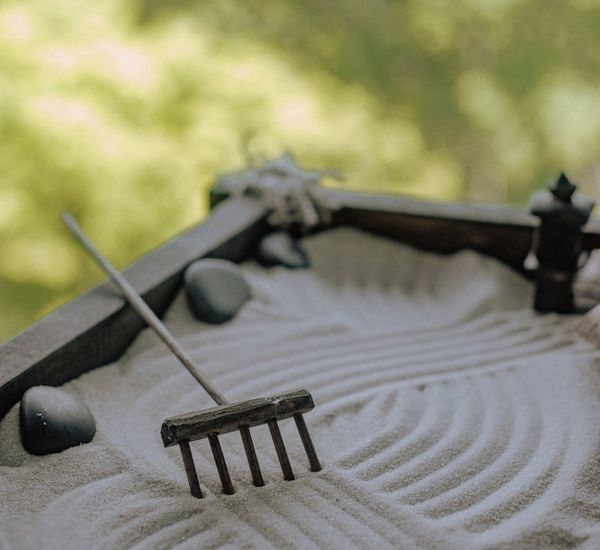 A serene zen garden with stacked stones and raked sand.