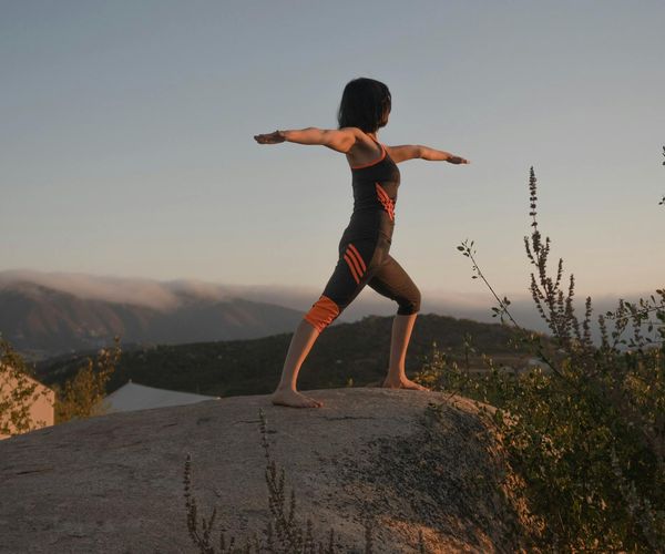 Person stretching gracefully outdoors during a golden sunset.